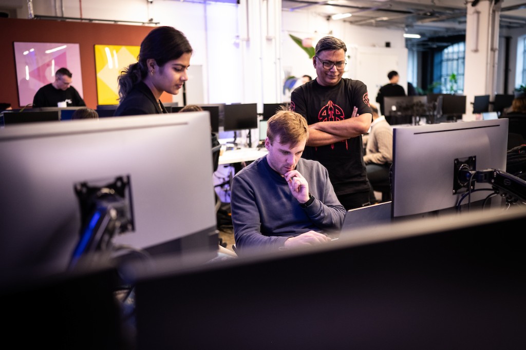 Participants collaborating around laptops during a workshop