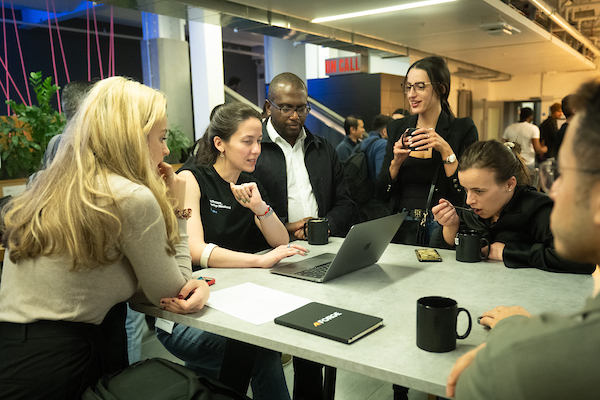 Team collaborating around a laptop during a workshop session